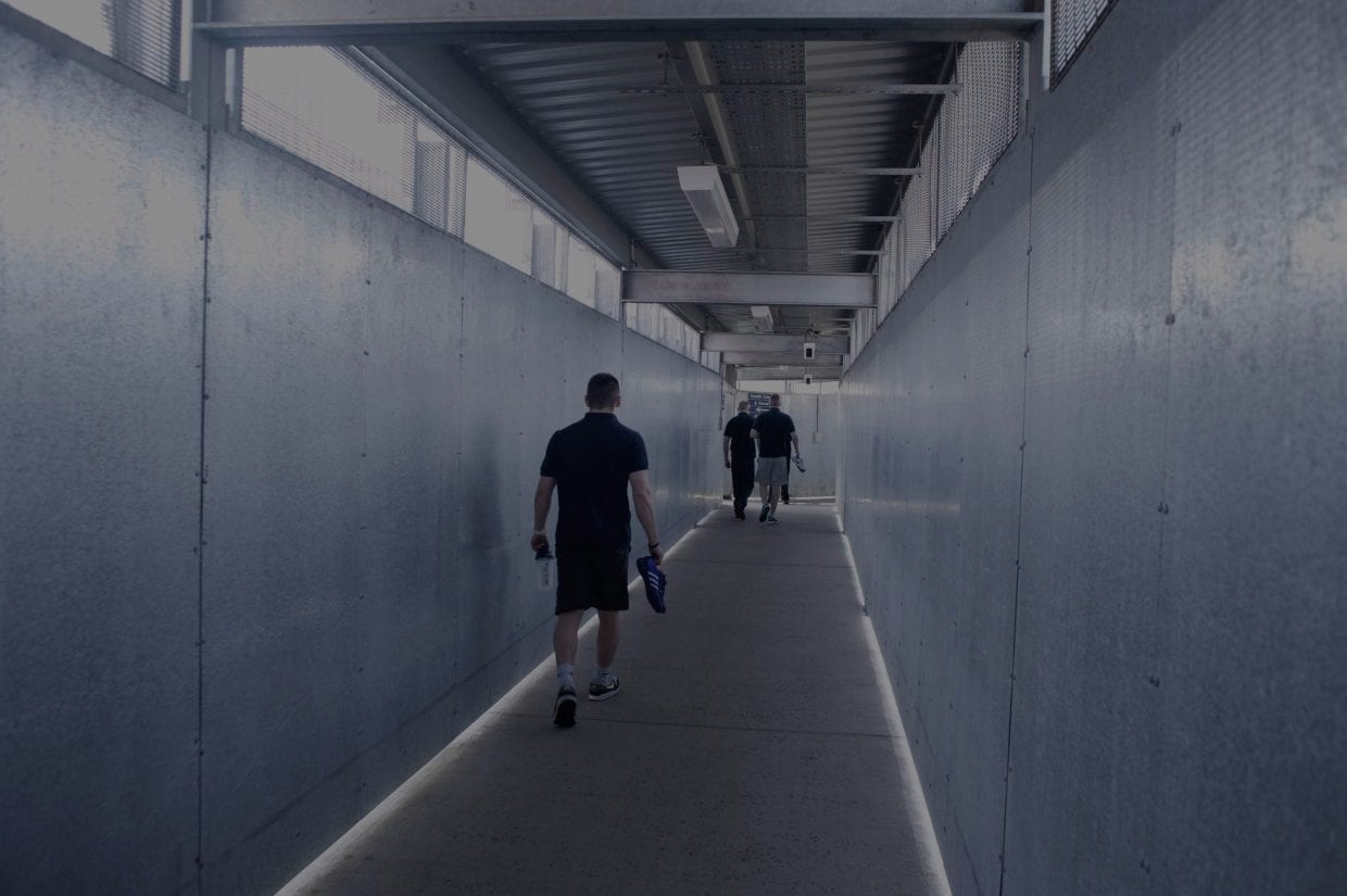 People walking down a plainly decorated corridor
