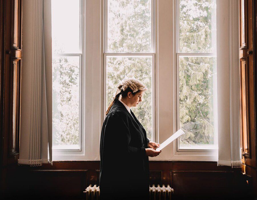 Sheriff Martin-Brown standing by a window reading papers