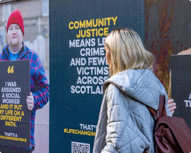 A person walking past 'Life Changing Sentence' campaign billboards